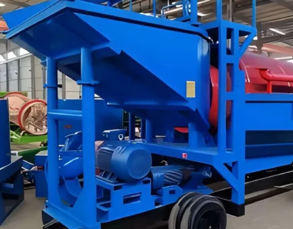 A blue metal screening and sorting machine with a motor and conveyor system in an industrial workshop.
